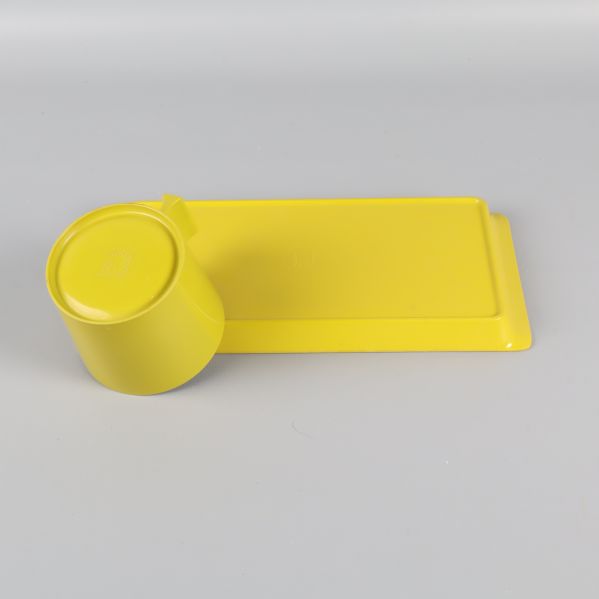 Undersidan av gul/grön kopp och bricka i plast