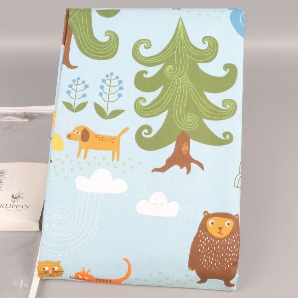 Uppvikt påslakan med gröna träd och olika djur