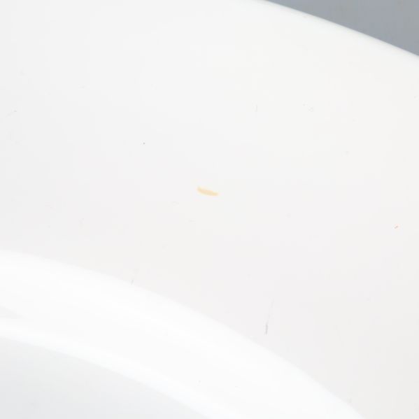 Liten fläck på kant av vit tallrik