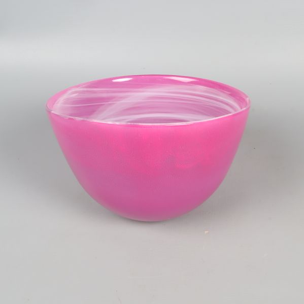 Yttre sida av rund rosa skål i glas mot grå bakgrund