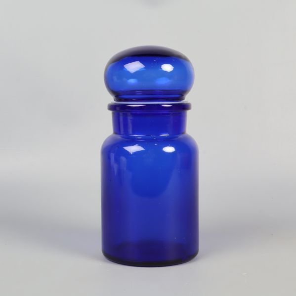 Framifrån vy av blå apoteksburk i glas