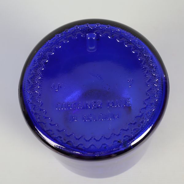 Botten av blå apoteksburk med präglad text