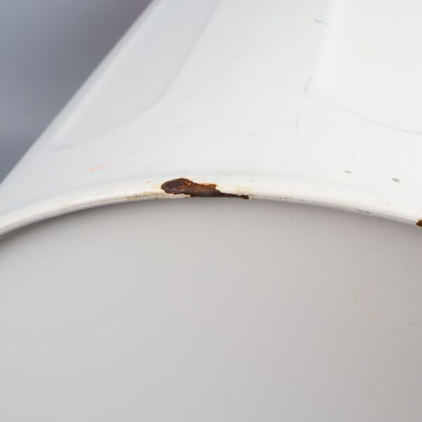 Närbild på rostskada vid papperskorgens kant
