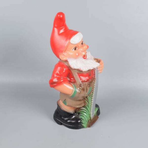 Trädgårdstomte i profil med såg och grönt gräs