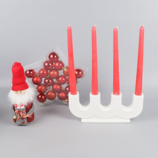 Tomtefigur, adventsljusstake och röda kulor arrangerade tillsammans