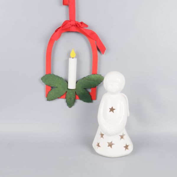 Vit ängellykta med stjärnor och röd hängprydnad med konstljus