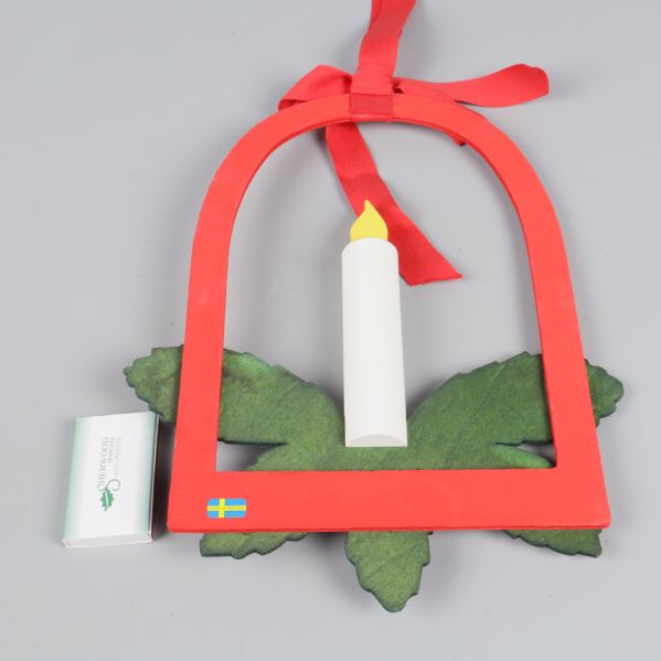 Röd och grön hängprydnad med konstgjort ljus och svensk flagga