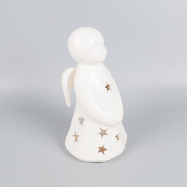 Vit ljuslykta formad som en ängel, star cutouts syns tydligt
