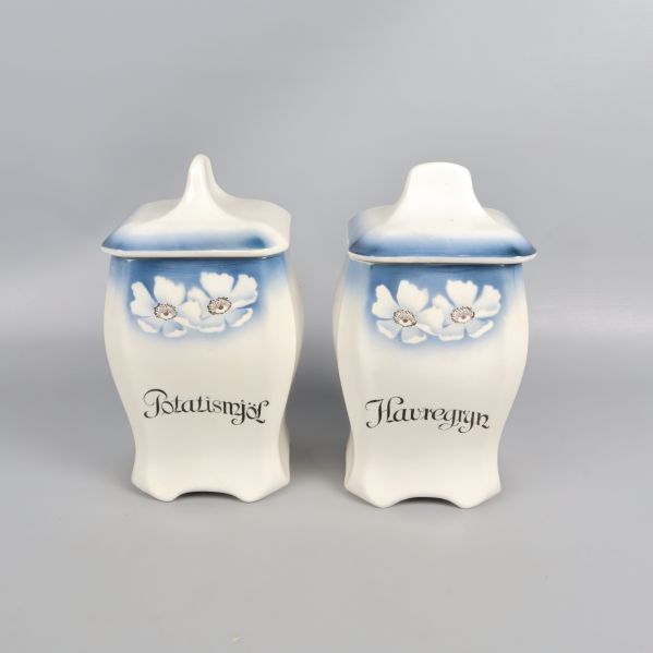 Två burkar med lock och blå blommotiv framtill