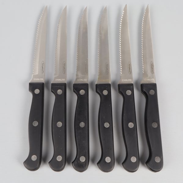 Sex köttknivar med svarta handtag och tandade blad