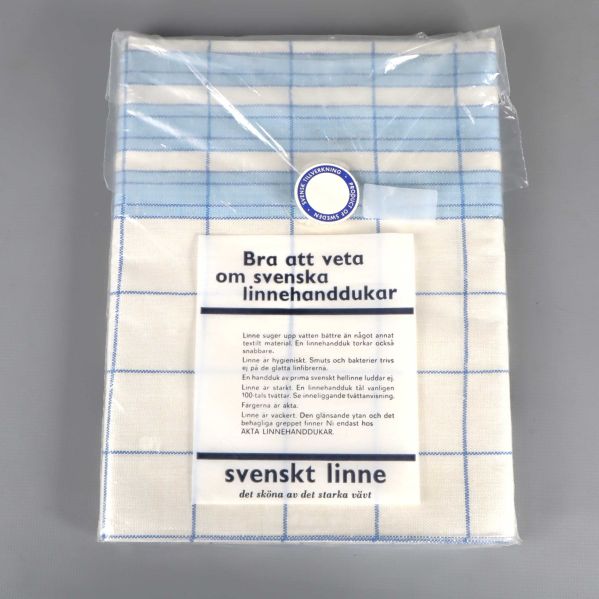 Baksidan av förpackad blåvit kökshandduk med informationsblad