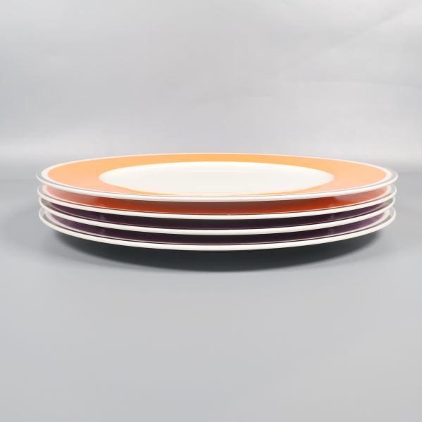 Fyra staplade tallrikar sedda från sidan