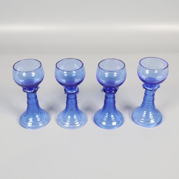 Fyra blå snapsglas i rad