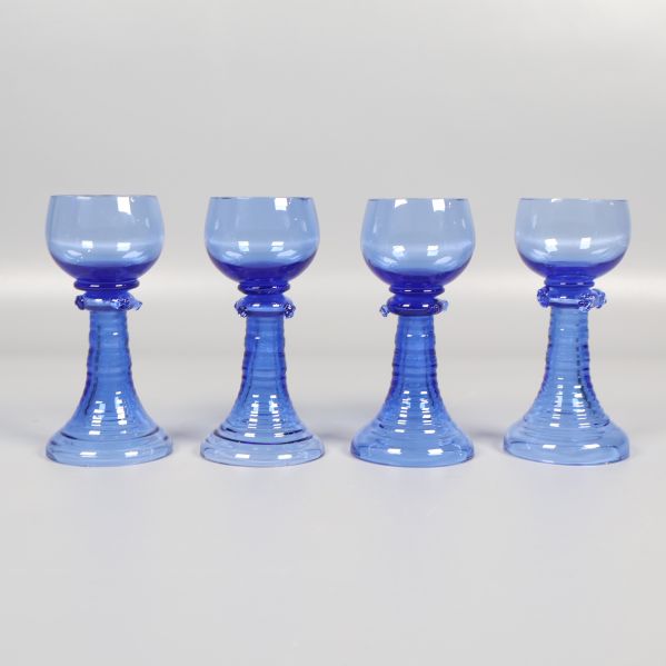Fyra blå snapsglas i rad