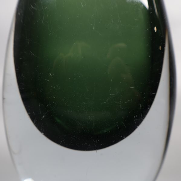 Närbild på grön glasvas med synliga repor