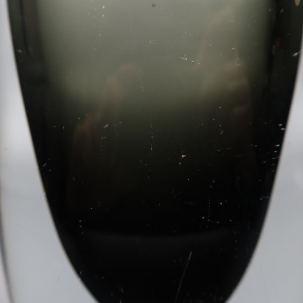 Närbild på större glasvas med synliga repor
