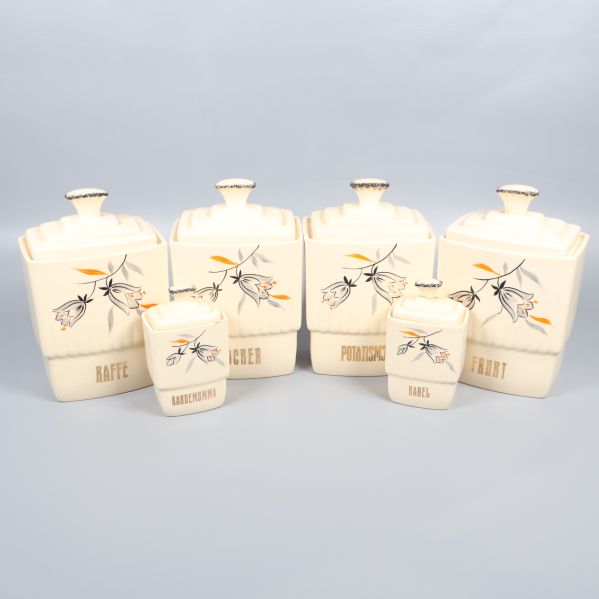 Sex krämfärgade förvaringsburkar med blommönster och texter