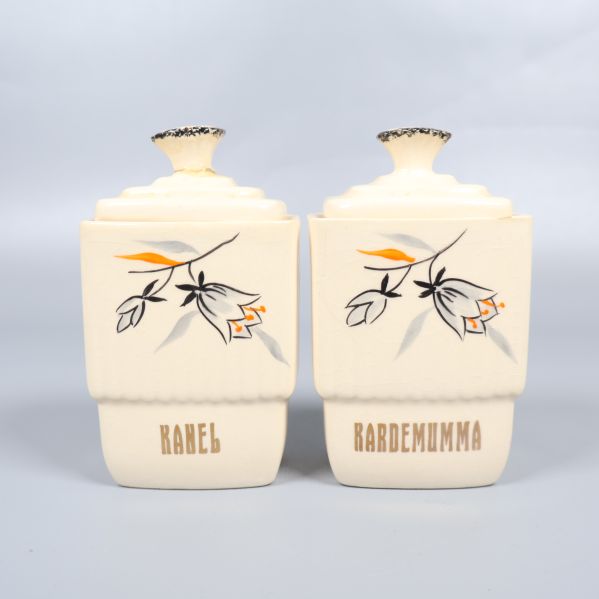 Två mindre förvaringsburkar med dekor och text kanel, kardemumma