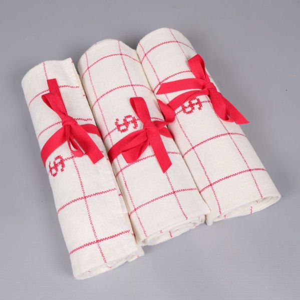 Tre hoprullade handdukar med röda band 