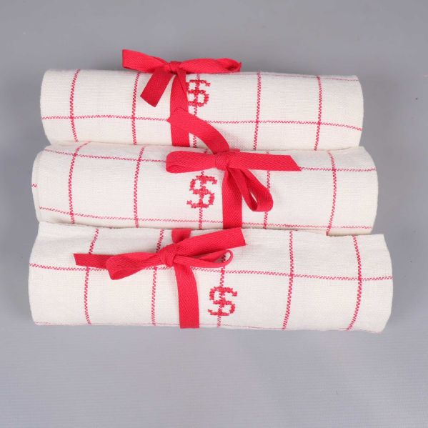 Tre kökshanddukar med monogram och röda rutor rullade ovanifrån