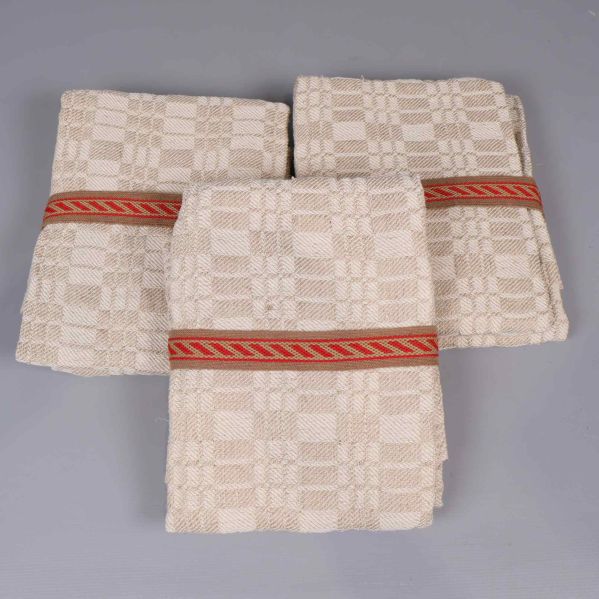 Tre vikta beige linnéhanddukar med röd bård