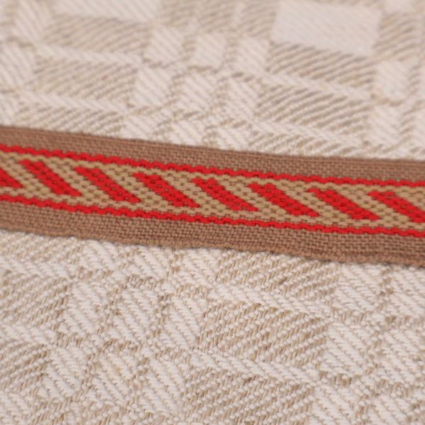 Detaljbild på röd bård med diagonala ränder på handduken