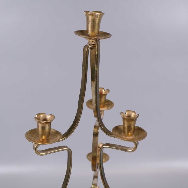 Närbild på kandelaberns övre ljushållare i mässing