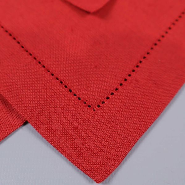 Närbild på röd tygservett med dekorativ hålsöm