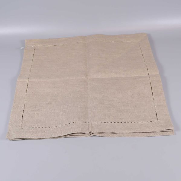 Beige fyrkantiga servetter helt utvikt på bord