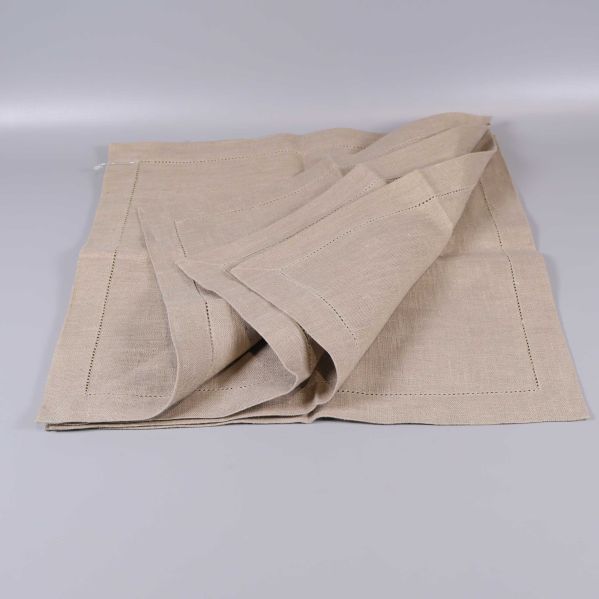 Flera vikta beige servetter staplade ovanpå varandra