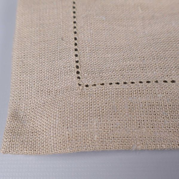 Närbild på hörnet av servett med dekorsöm