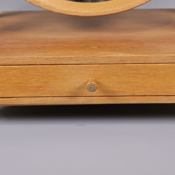 Närbild på lådans handtag och främre del av träbasen