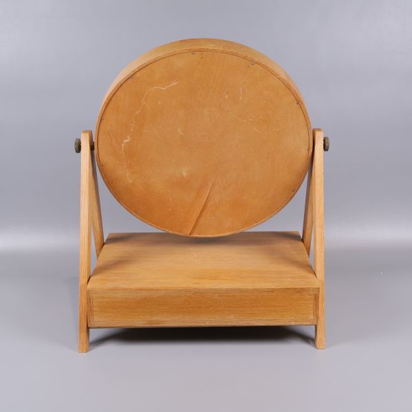 Baksida av rund spegel i ljust trä visar trästruktur