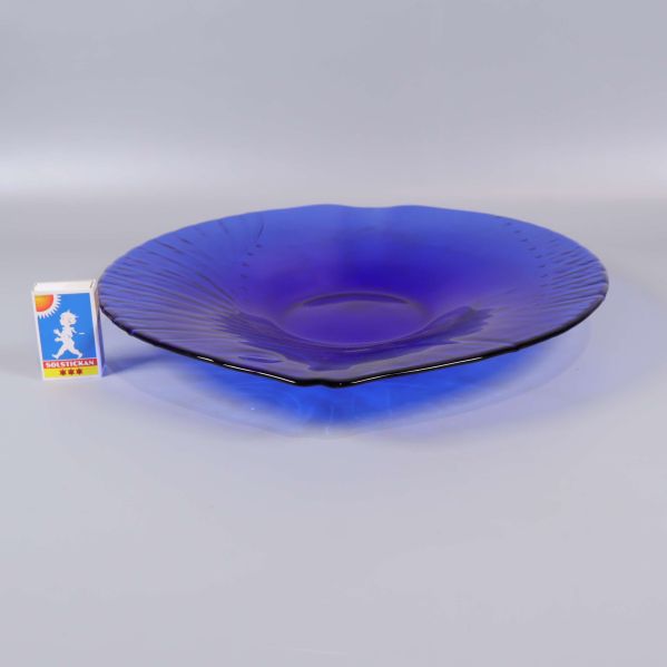 Blå fiskformad skål bredvid tändsticksask för storleksjämförelse