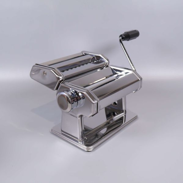 Närbild på glänsande pastamaskin från sned vinkel