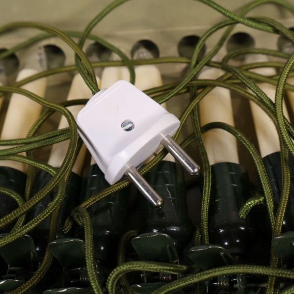 Vit europeisk stickpropp ansluten till grön kabel