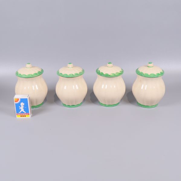 Baksidan av fyra kryddburkar med lock samt en tändsticksask som storleksreferens