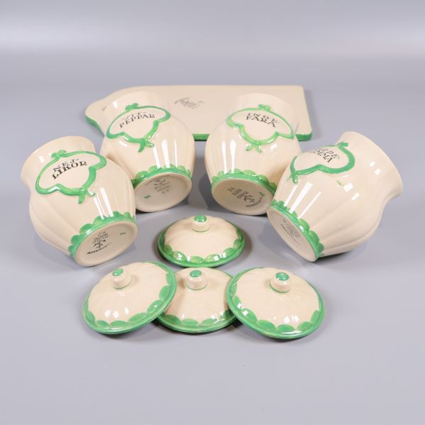 Kryddburkar och lock placerade på sidan tillsammans med skärbräda