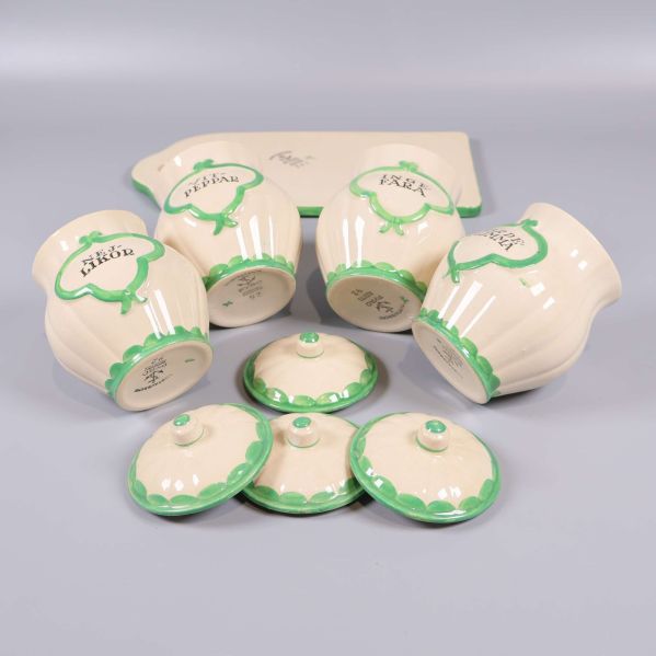 Fyra burkar och lock liggande ner, märkning synlig