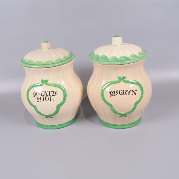 Två förvaringsburkar med grön kant och text Potatismjöl och Risgryn