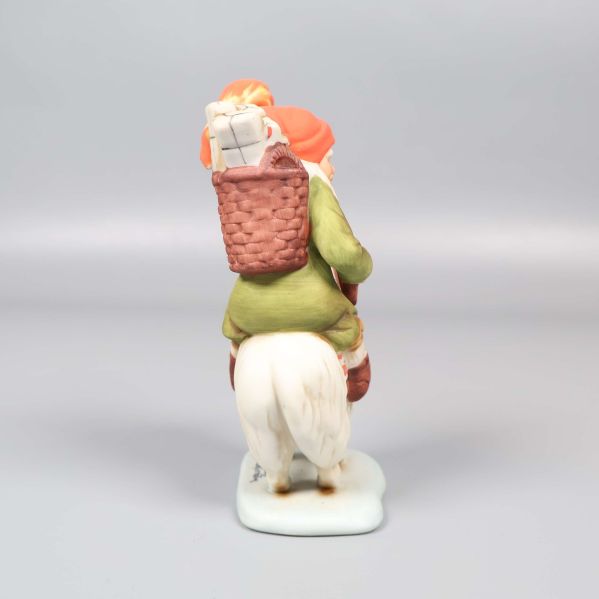 Tomtefigur sedd bakifrån visar korg och luva