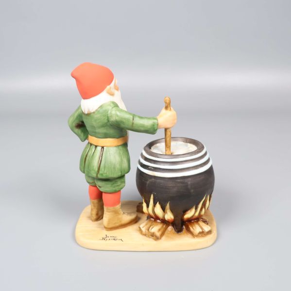 Tomtefigur sedd bakifrån, tomten håller i slev vid gryta