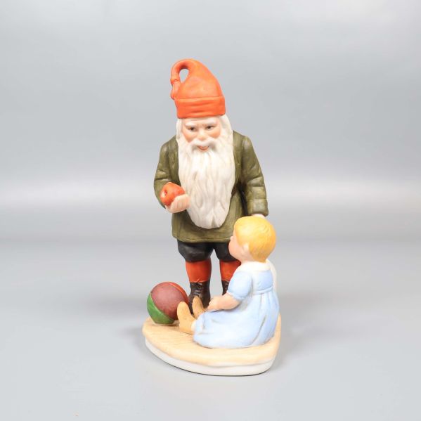 Tomtefigur framifrån bredvid sittande barn