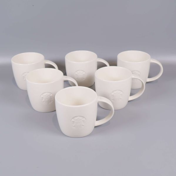 Sex vita muggar med reliefmönster framifrån