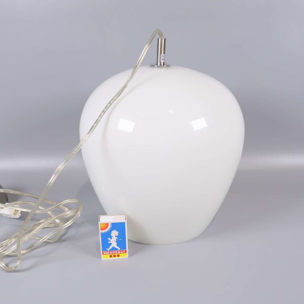 Närbild på taklampans form med platt botten och tändsticksask för skala