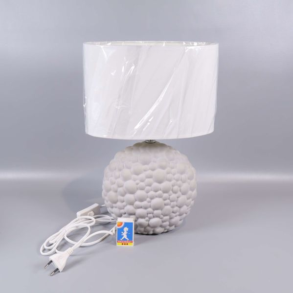 Vit bordslampa med bubblig struktur och strömbrytare på sladden