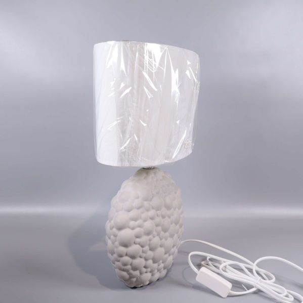 Sidosyn på vit bordslampa med mönster och vit sladd