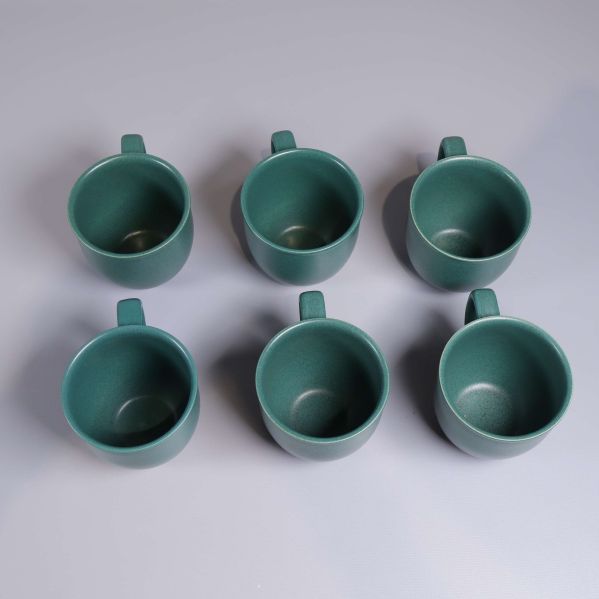 Sex gröna kaffekoppar fotograferade ovanifrån
