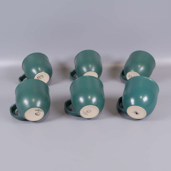 Sex gröna kaffekoppar visade underifrån för att visa botten