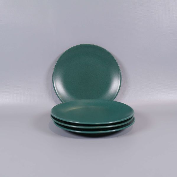 Fyra assietter staplade med en stående bakom